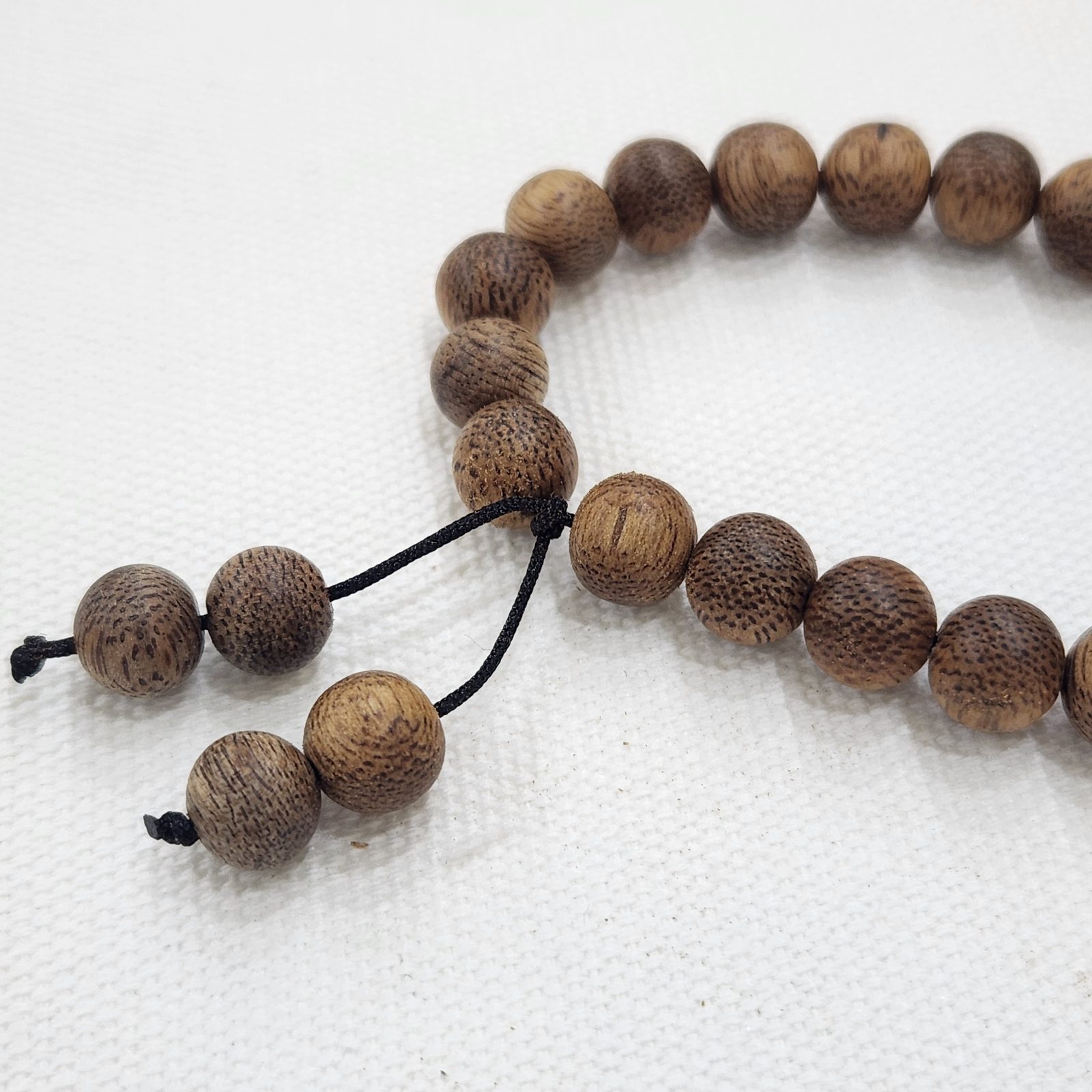 Close-up of agarwood beads and adjustable knot